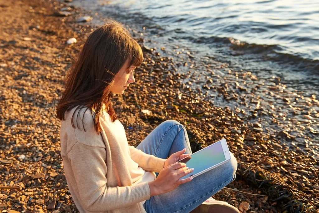 Woman sitting quietly by the sea taking time to slow down anxious thoughts and reconnect with the present moment