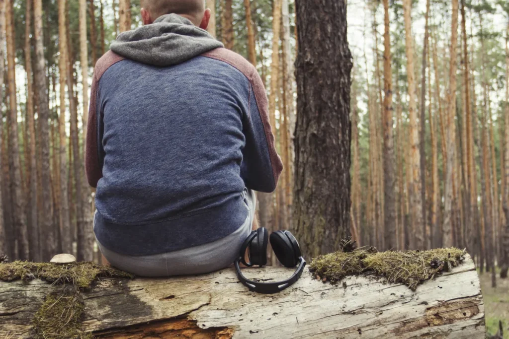Man sitting alone in woodland reflecting on stress, support and emotional wellbeing
