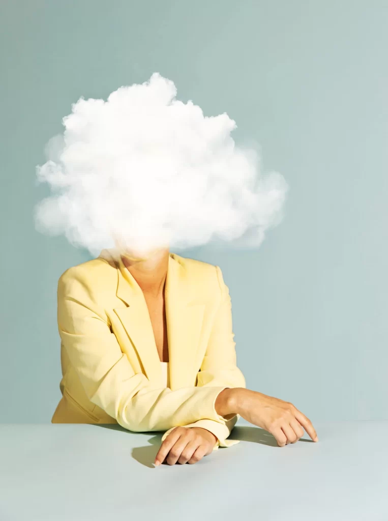 Woman with a cloud above her head, representing the mental chaos of ADHD. Therapy and ADHD coaching can help manage these overwhelming thoughts.