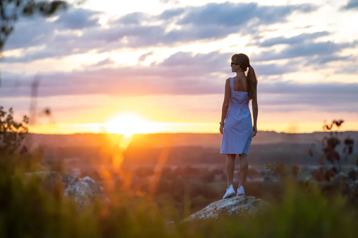 Woman reflecting at sunset while thinking about ADHD, overwhelm and self-understanding