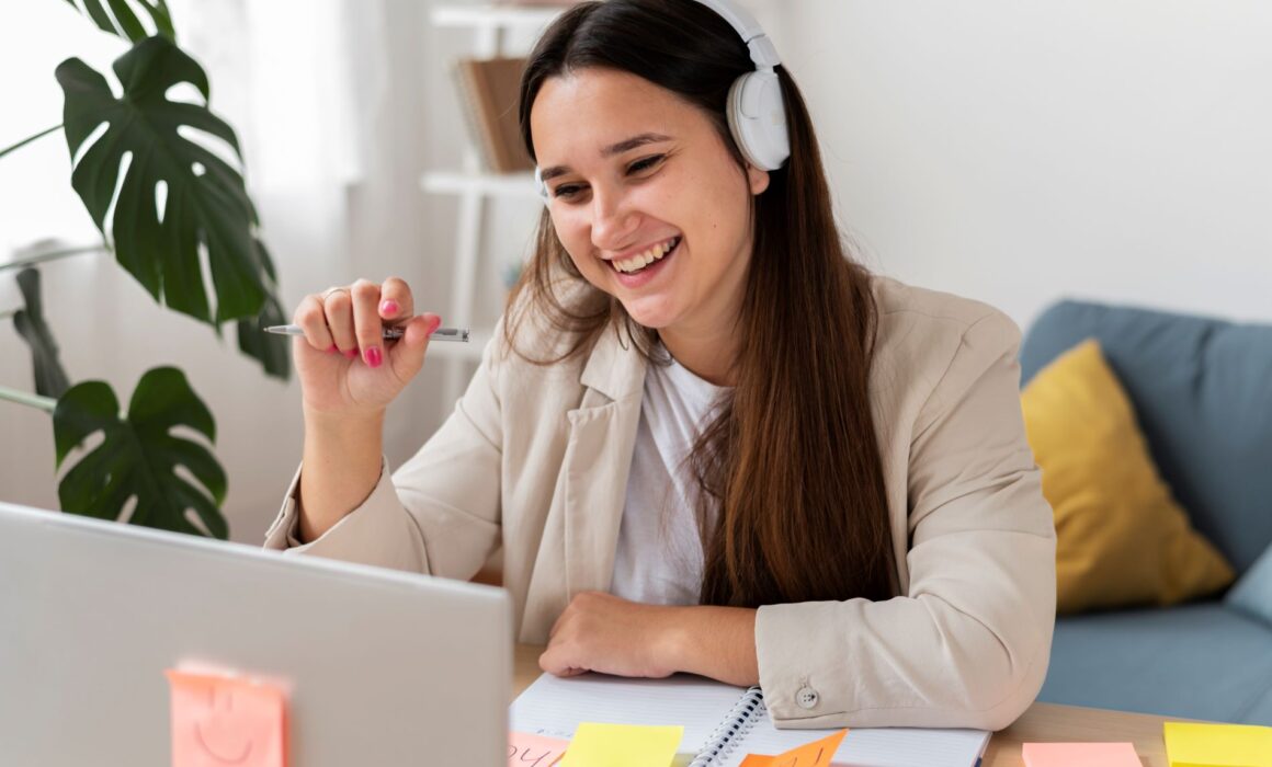Person at a desk with an open laptop and sticky notes, representing organisation strategies in Access to Work ADHD coaching.