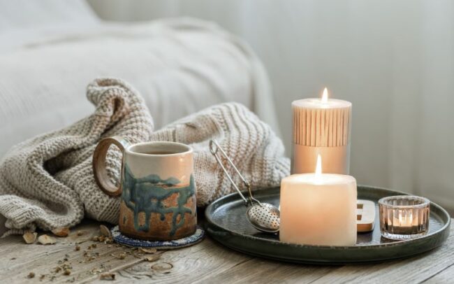 cozy composition with mug, candles and a blanket representing grounding exercises