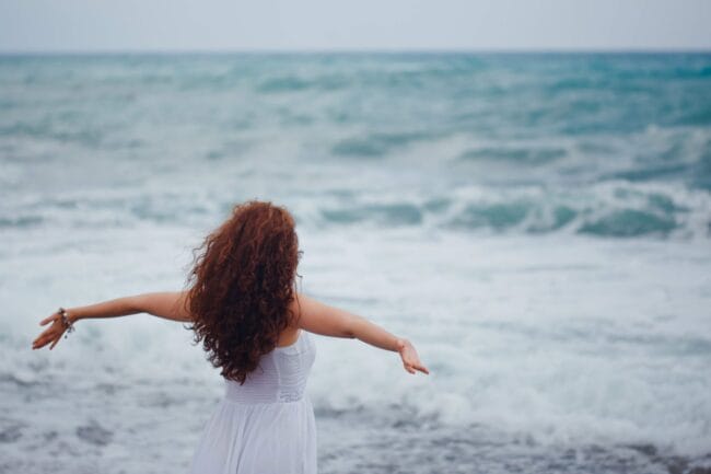 lady standing with arms out, representing releasing anxiety after listing to releasing anxiety self-hypnosis