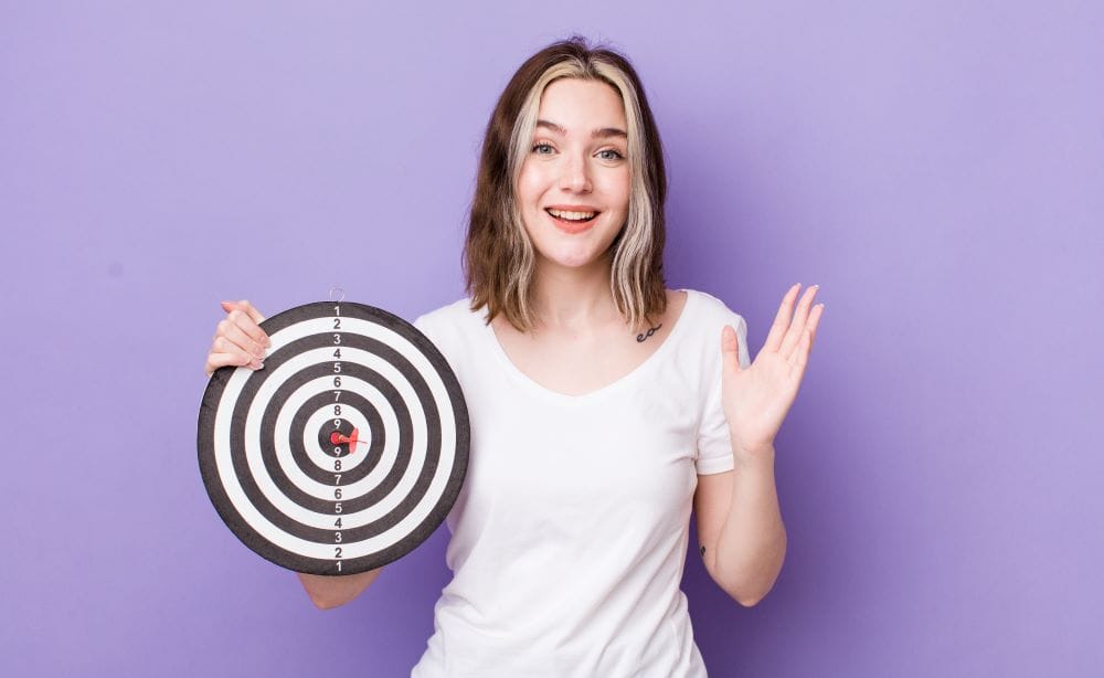 woman holding target board representing achieving lasting success