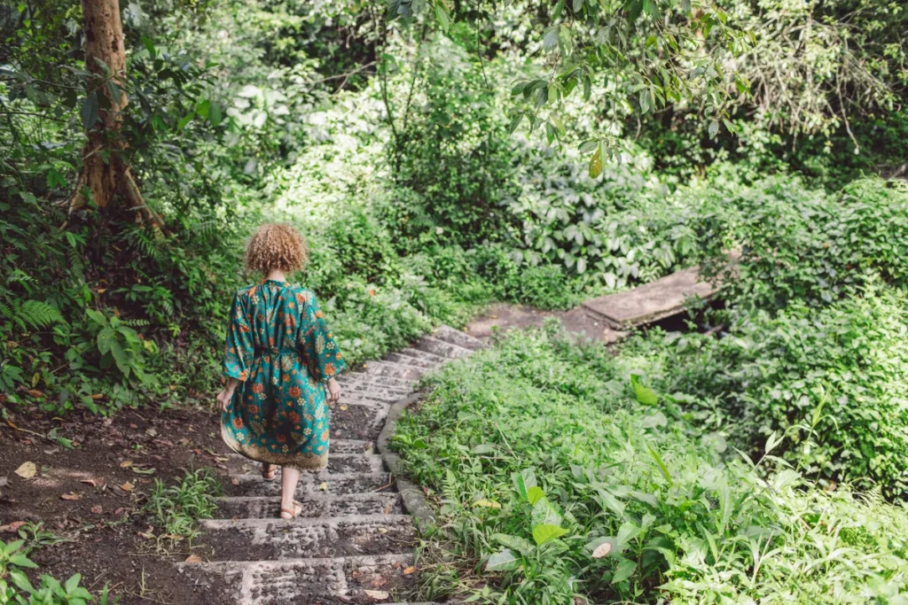 Woman walking down a woodland path taking one step at a time during a period of change