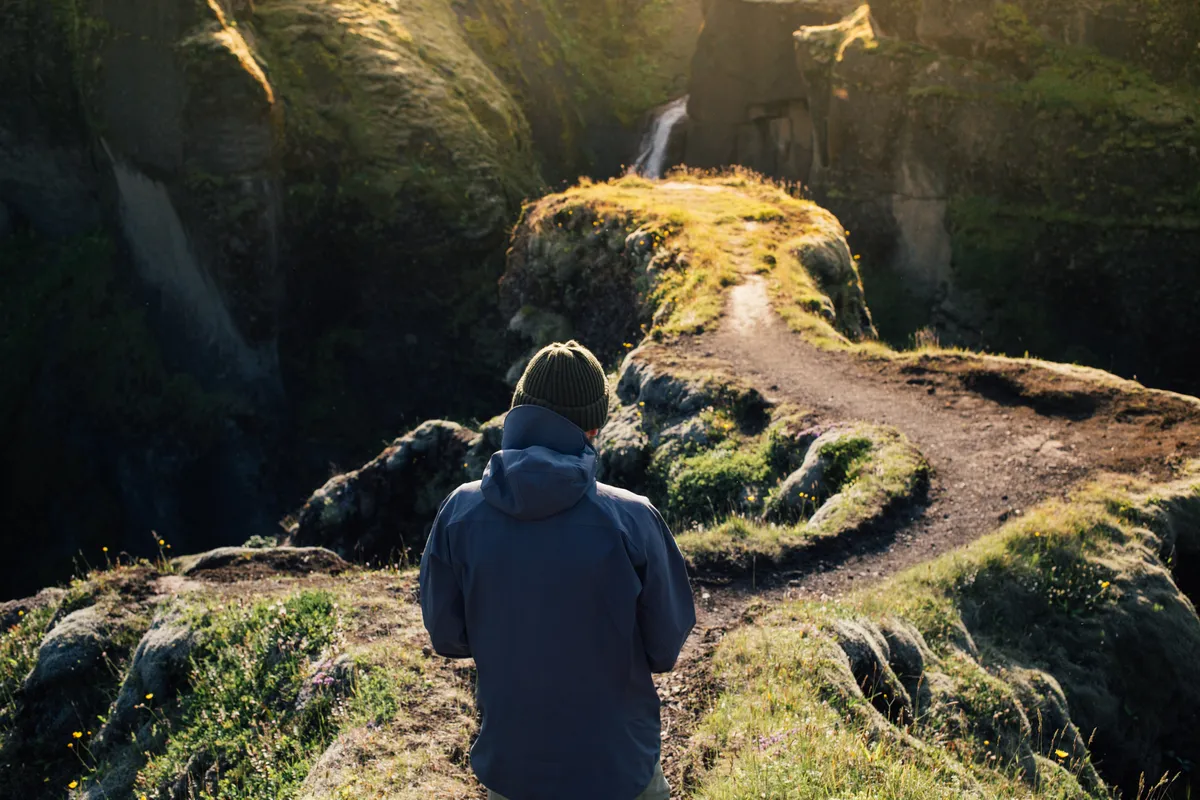 Person walking along a woodland path reflecting on change and personal growth