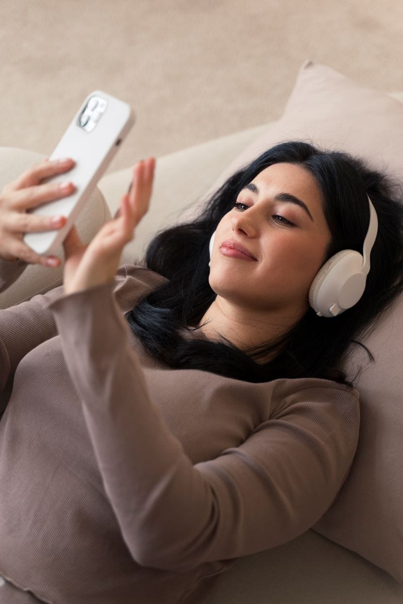 Relaxing Sleep Meditation – Woman Listening with Headphones Woman sitting in a chair with headphones on, peacefully listening to a guided sleep hypnosis meditation