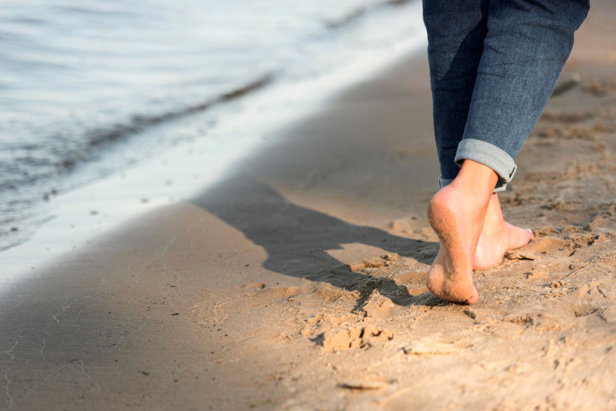 Woman walking by the sea reflecting on her thoughts – a moment of calm to reduce stress