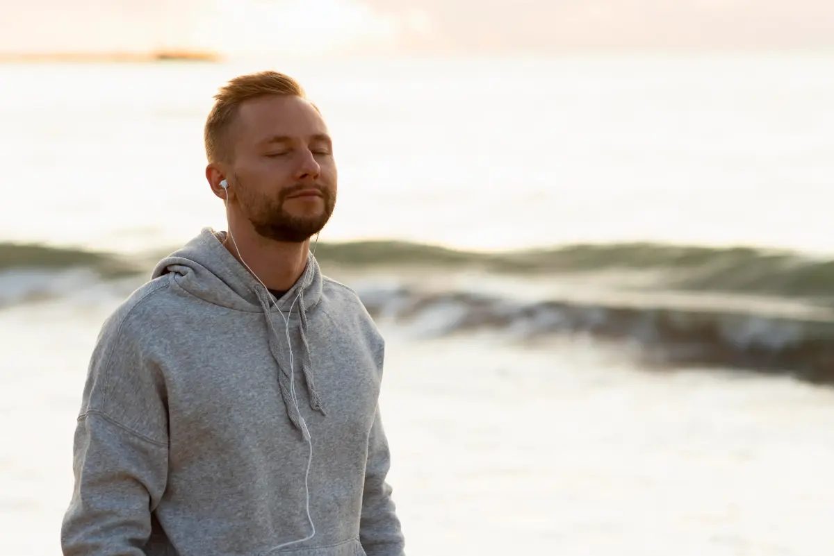 Man standing outdoors by the sea, representing calm and emotional regulation