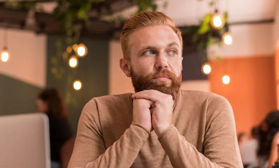 Man sitting quietly, appearing thoughtful and inwardly focused, reflecting the physical experience of anxiety