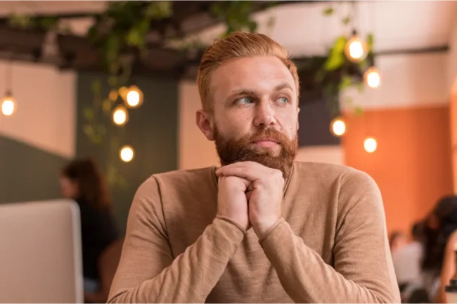 Man sitting quietly, appearing thoughtful and inwardly focused, reflecting the physical experience of anxiety