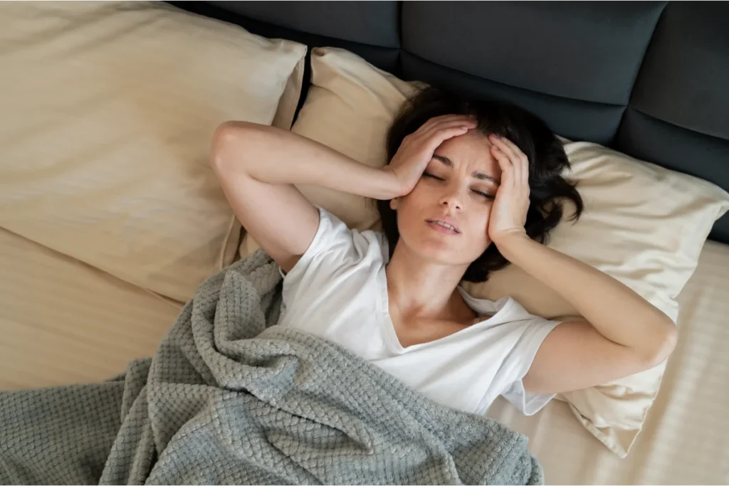 Woman resting in bed during a quiet morning, reflecting mental overload when life slows down