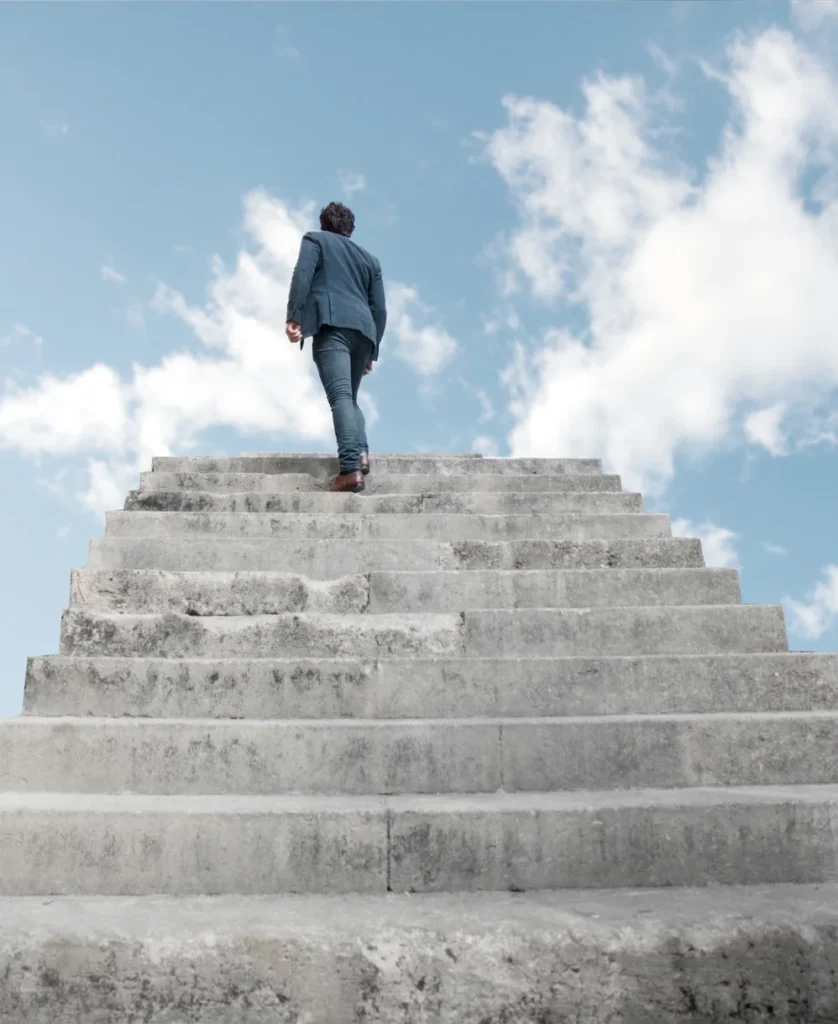 Person walking up steps, representing gradual progress and support