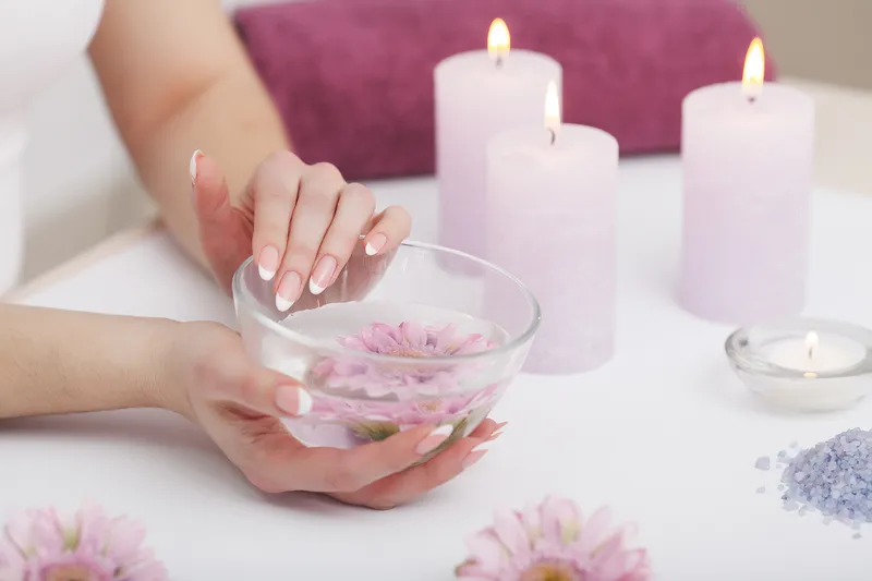 Hand holding a lit candle in a calm indoor setting