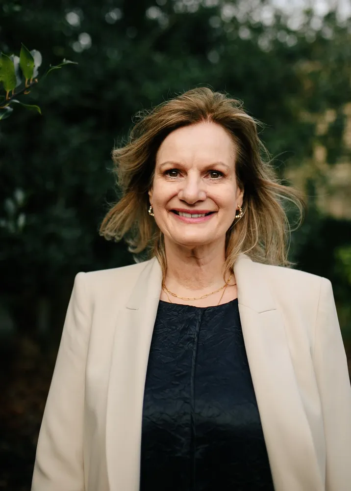Carol Gordon smiling outdoors in a cream blazer, welcoming clients for online counselling at Clear Haven Therapy