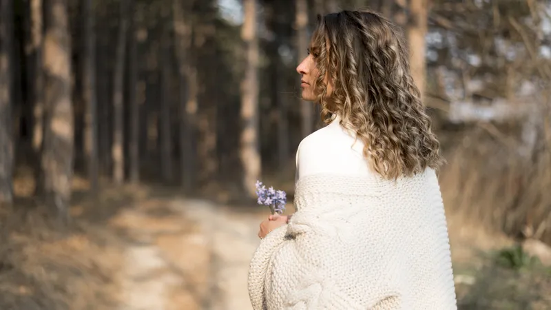 Woman reflecting in a woodland setting while coping with relationship anxiety and overthinking