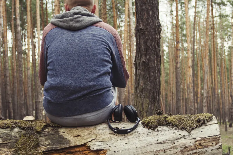 Man sitting alone in woodland reflecting on stress, support and emotional wellbeing