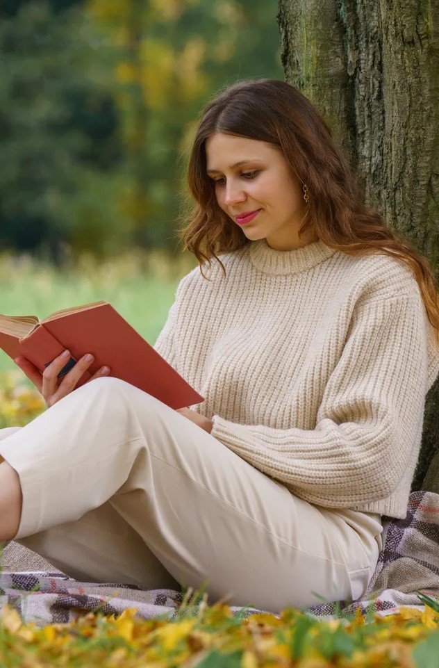 Woman reading in a peaceful outdoor setting, representing the calm and reflective space offered through online counselling at Clear Haven Therapy