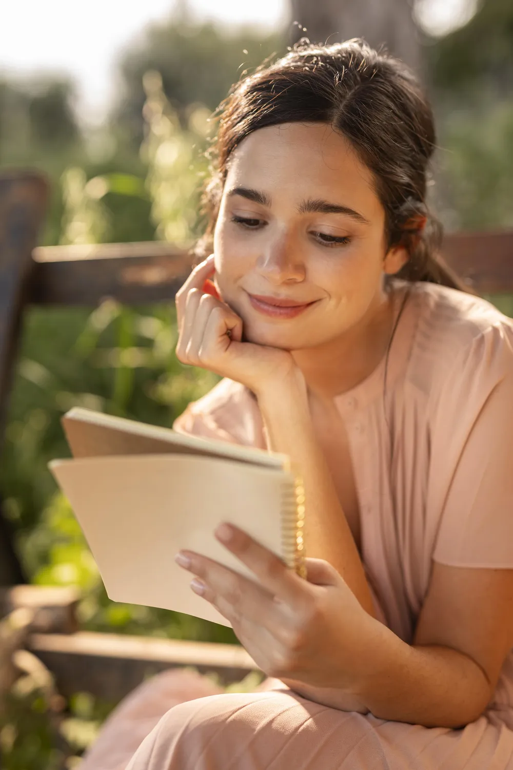 Woman reading and writing in a notebook while working through an ADHD programme outdoors.