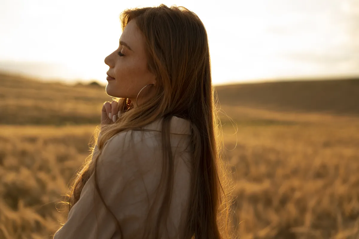Woman reflecting outdoors, representing the self-awareness and personal growth explored through transformational therapy.